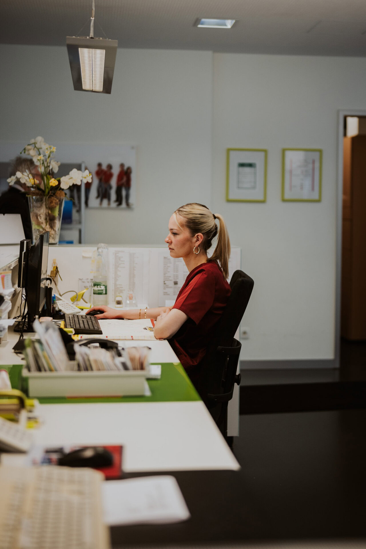 Eine MFA arbeitet an der Rezeption an einem Computer.